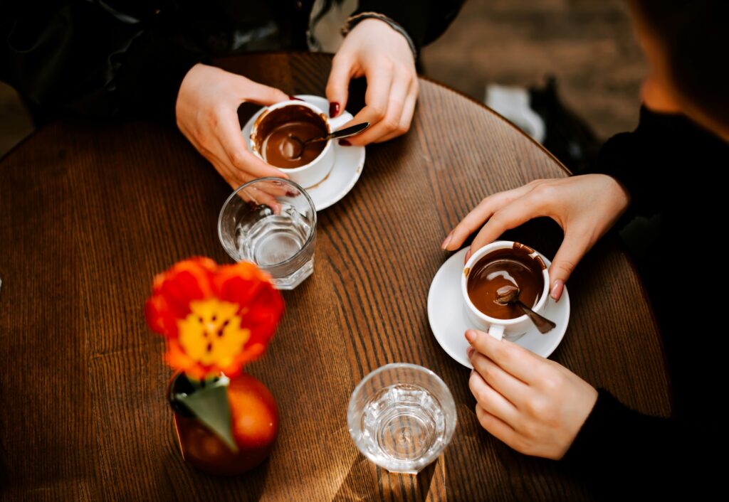 Two people sharing coffee at a café table, seen from above